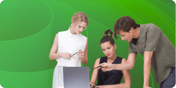 Coworkers gather around a laptop for collaboration.