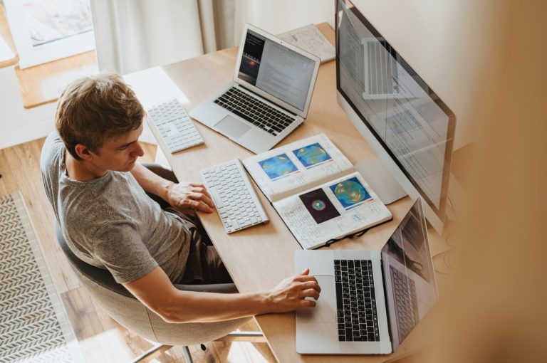 Developer working on three screens of code at the same time.