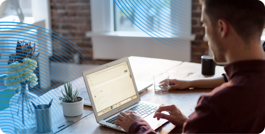 A CTO is seen from behind sitting at a desk working on a laptop.