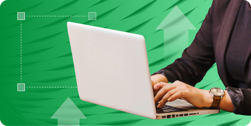 A close-up of someone typing on a white laptop, wearing a brown watch and a dark suit, with a green background that has subtle arrows and dotted square lines.