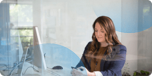 CTO sitting down at her desk looking at her phone in her hands.